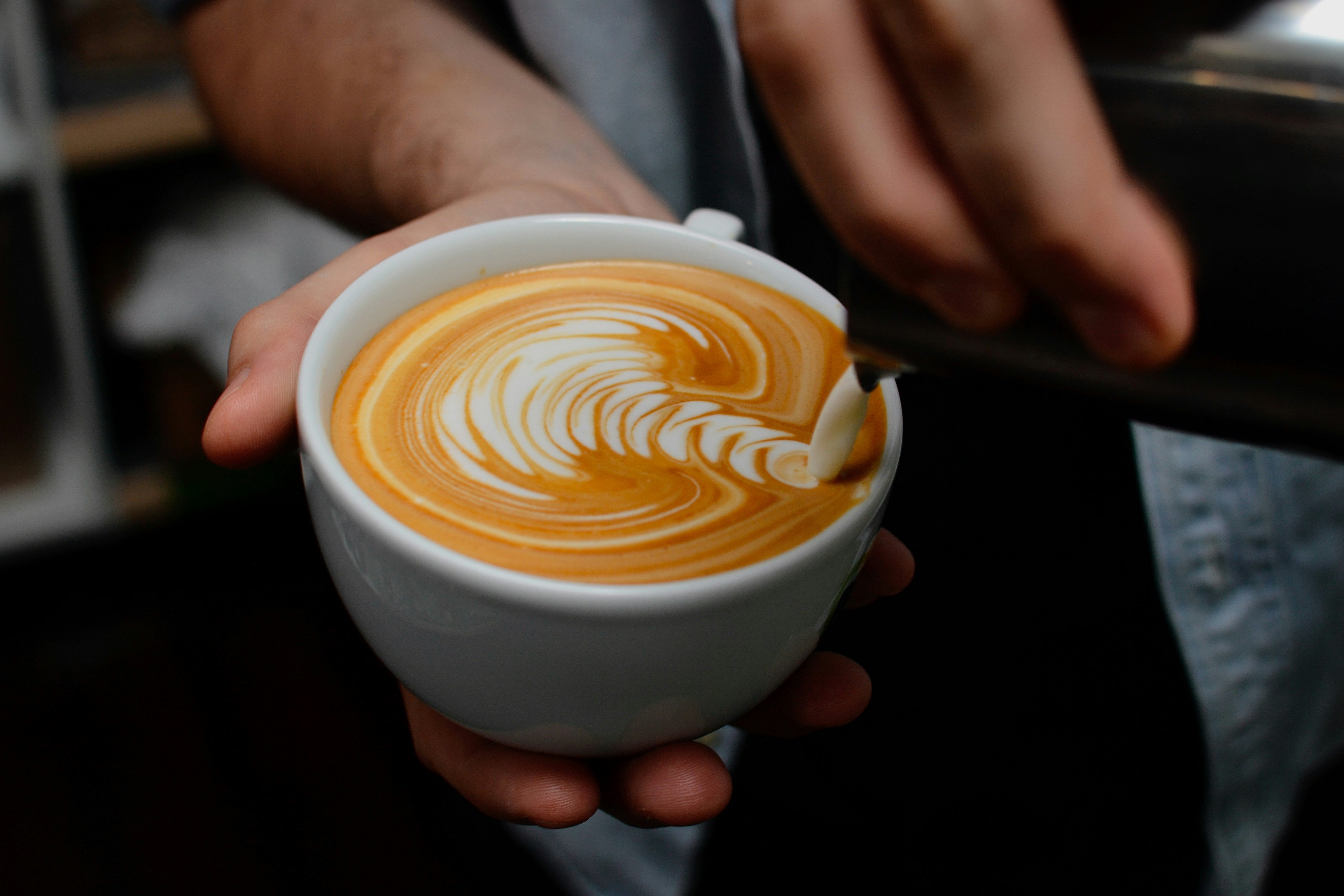 Hand pouring water onto coffee in a V60 dripper